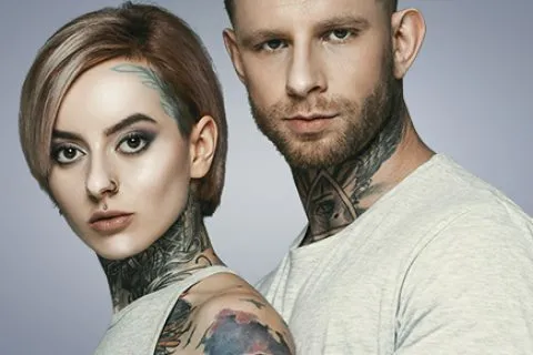 Male and female with neck tattoos on grey background
