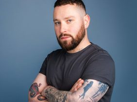 blog post image of a male with tattoo on arms on blue background